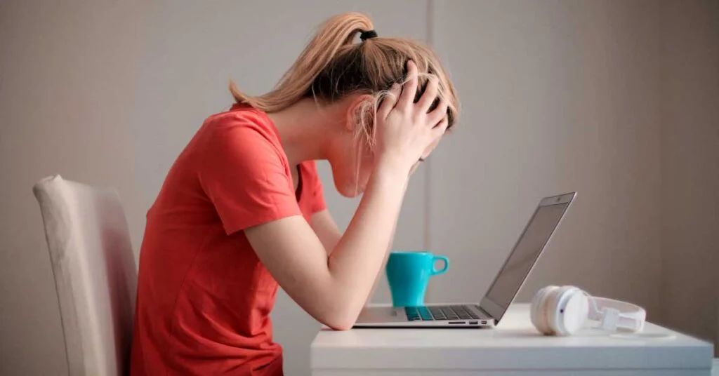 Woman sitting in front of laptop looking frustrated