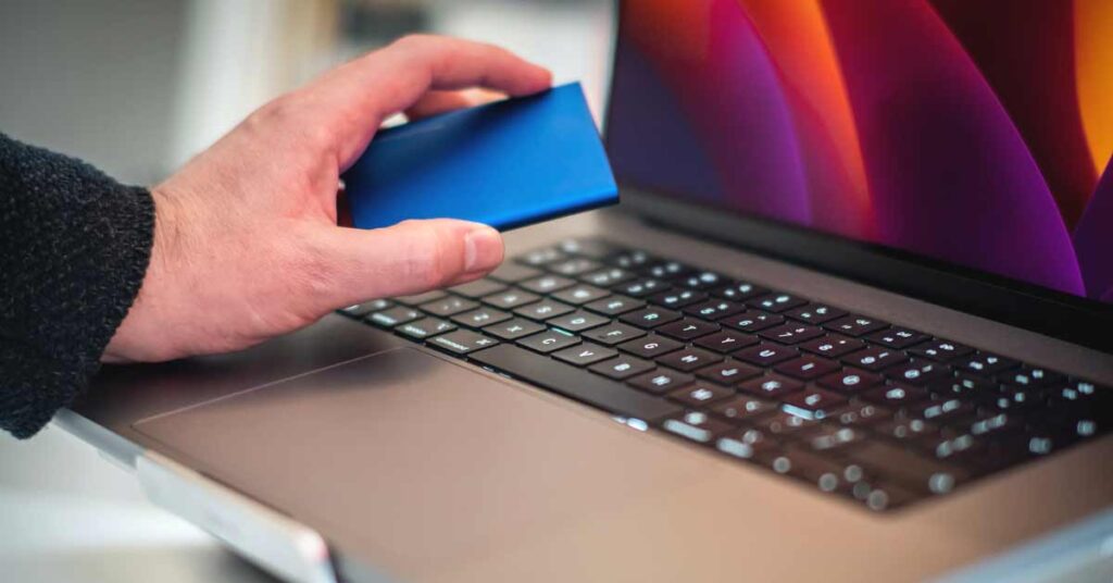 Image of laptop with person connecting SSD drive
