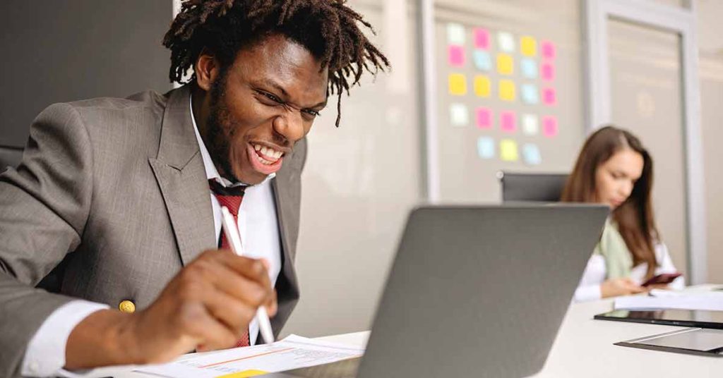 Person staring at laptop excitedly